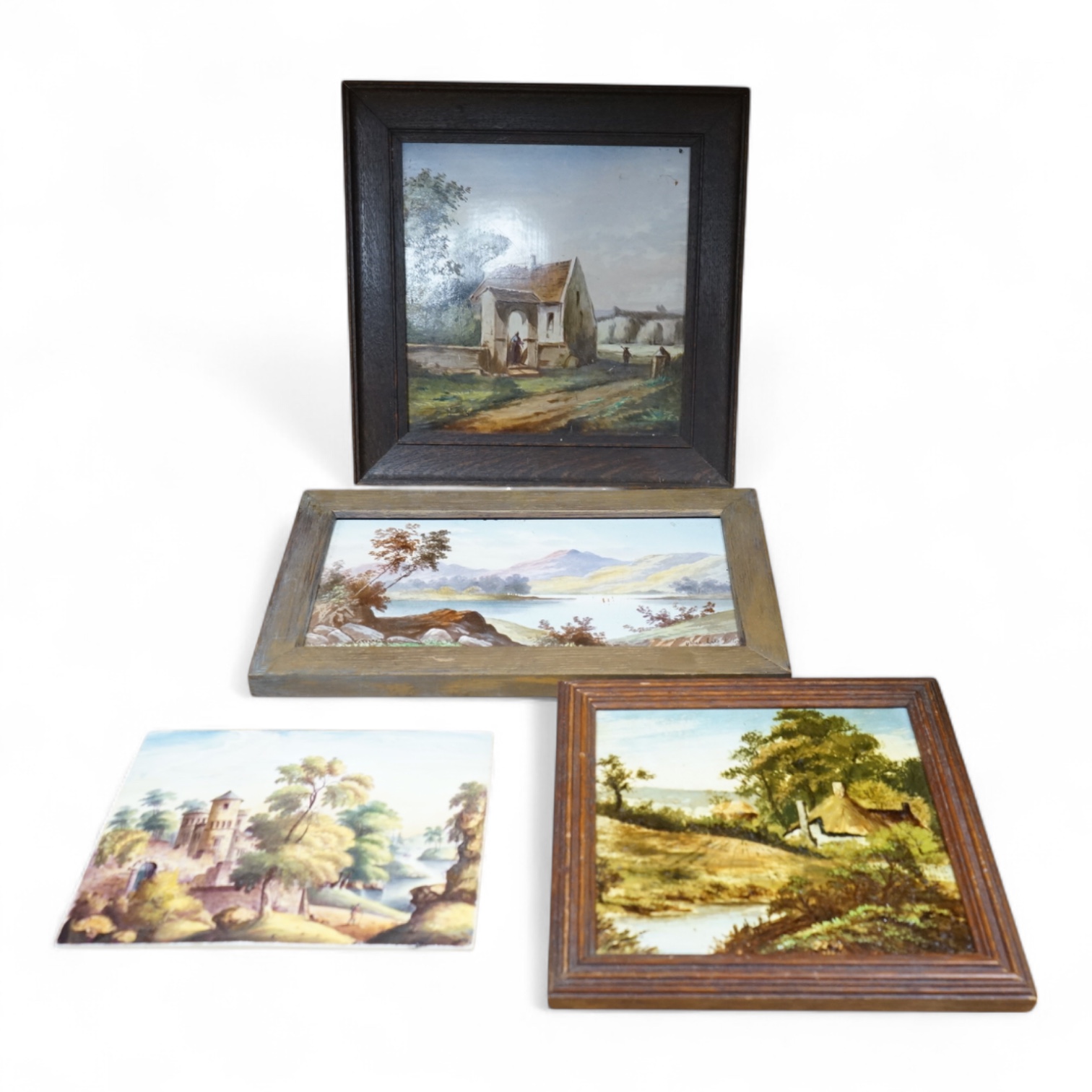Four ceramic painted plaques depicting landscapes to include ‘Upper Lake Killard’, three framed, largest 36cm wide